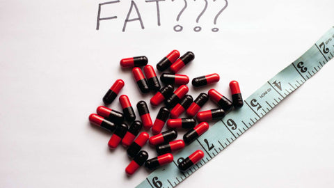 Weight loss concept with fat burner pills and measuring tape