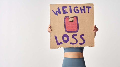 person holding a cardboard with weight loss message