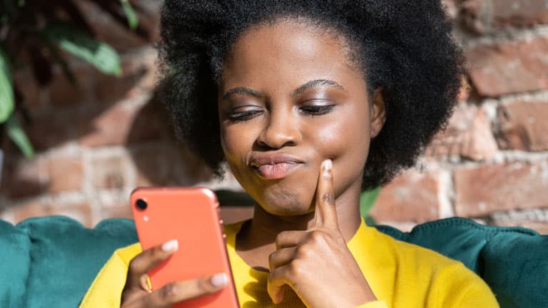 beautiful african woman choosing hair colour on her phone