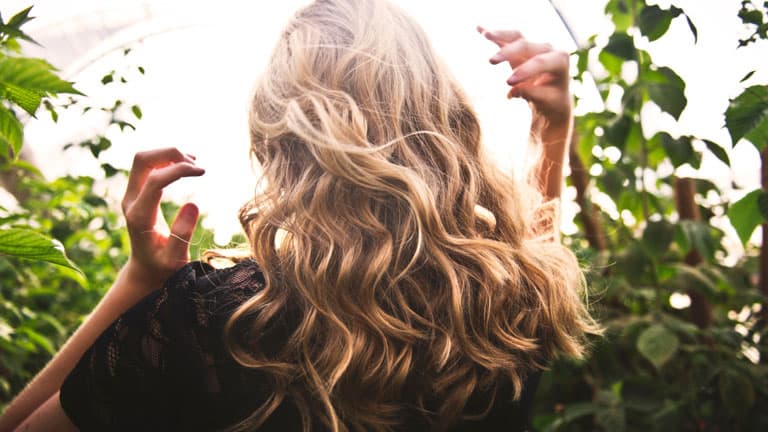 woman with shimmering wavy blonde hair in the sunlight