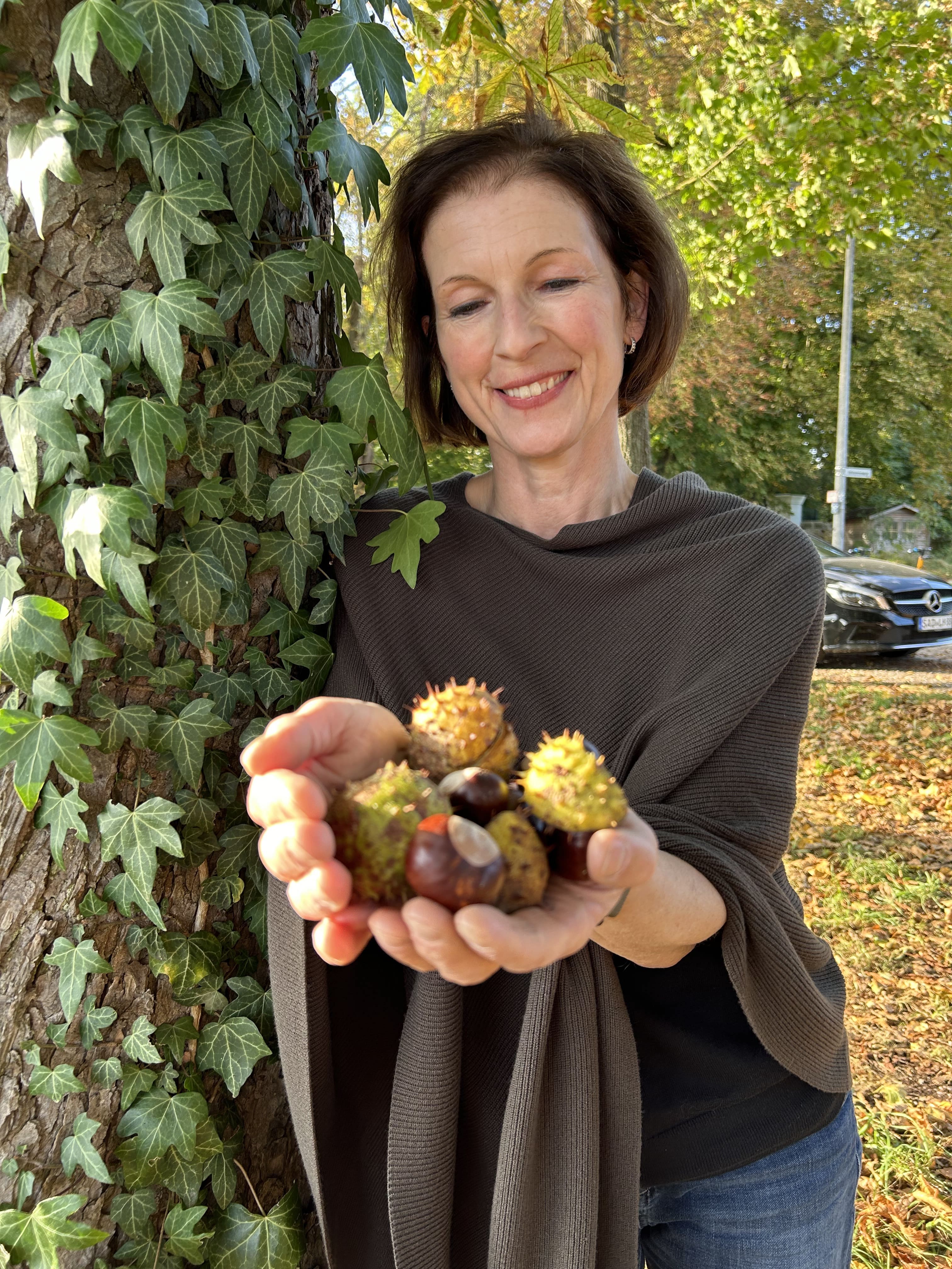 La pharmacienne Anja Heinz avec des marrons à la main dans une avenue