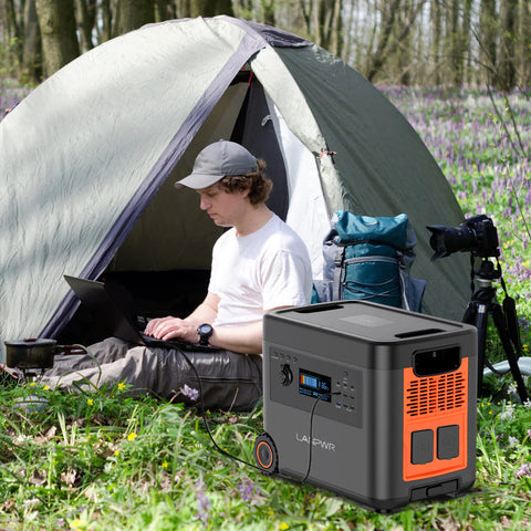 A man using the LANPWR D5-2500 Portable Power Station Solar Generator to work outdoors