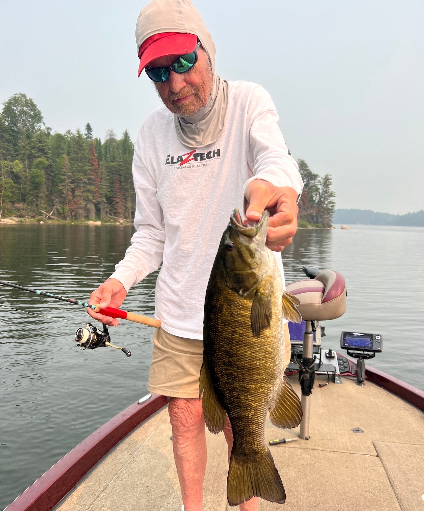 Drew Reese with a Large Mouth bass and holding his Rod