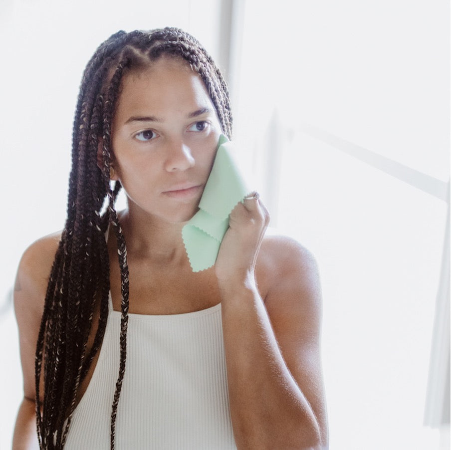 Alt: young lady exfoliating with a cloth