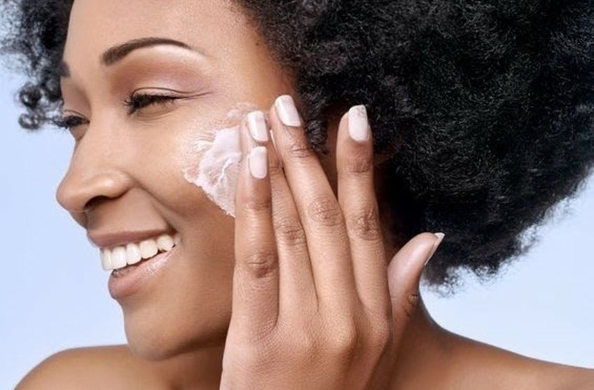 Woman applying skin cream to her face