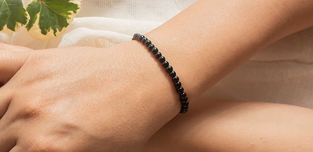female hand wearing collection of tiny gemstone bracelets Stock Photo -  Alamy