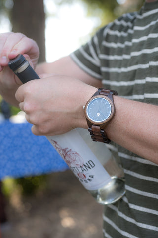 Man Wearing a Tree Hut Wood Watch Opening a Bottle of Alcohol Vodka