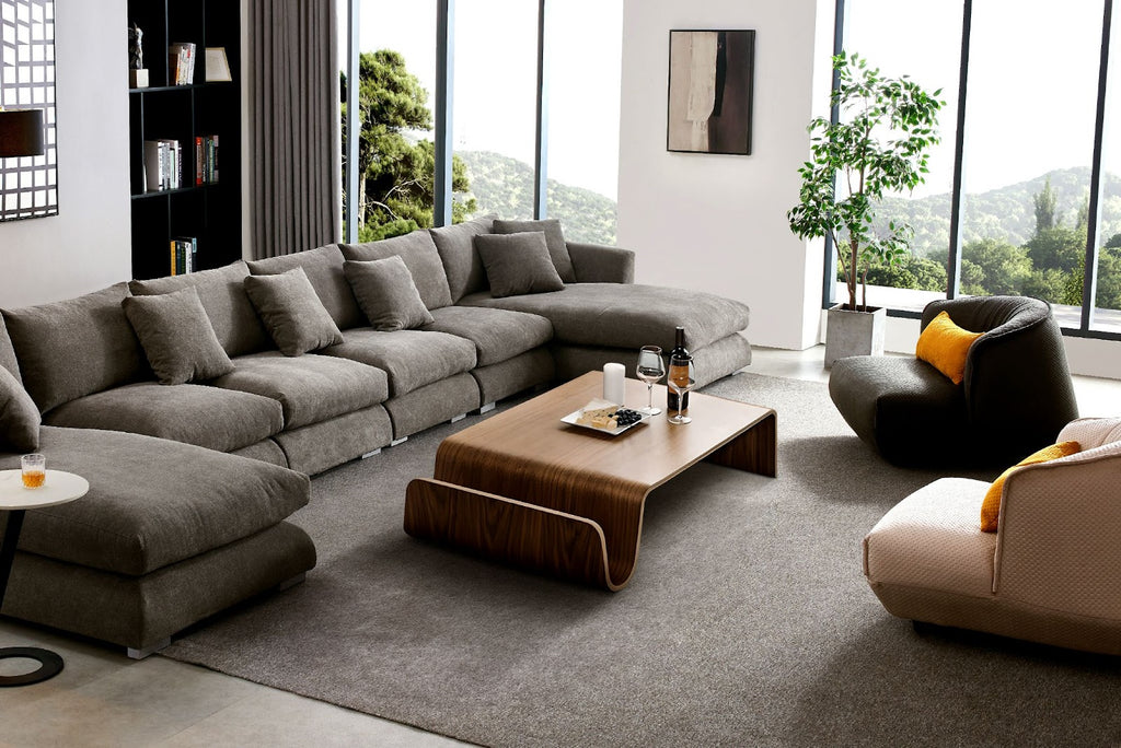 Modern living room with grey sectional couch, coffee table, and two accent chairs.