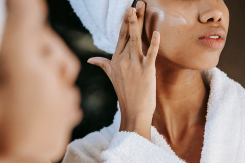 A person applying a fragrance-free skincare product to their face