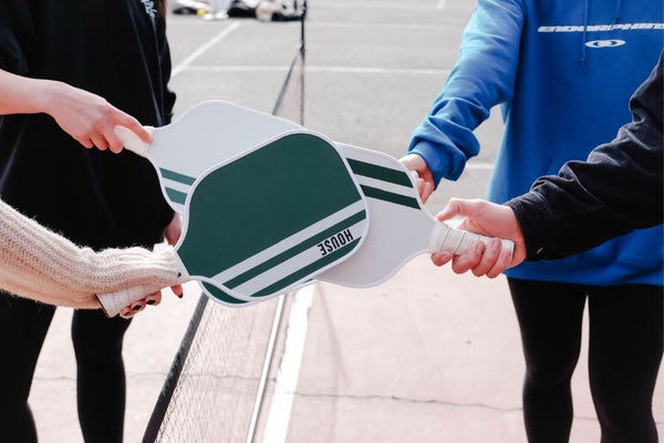 pickleball players holding house paddles