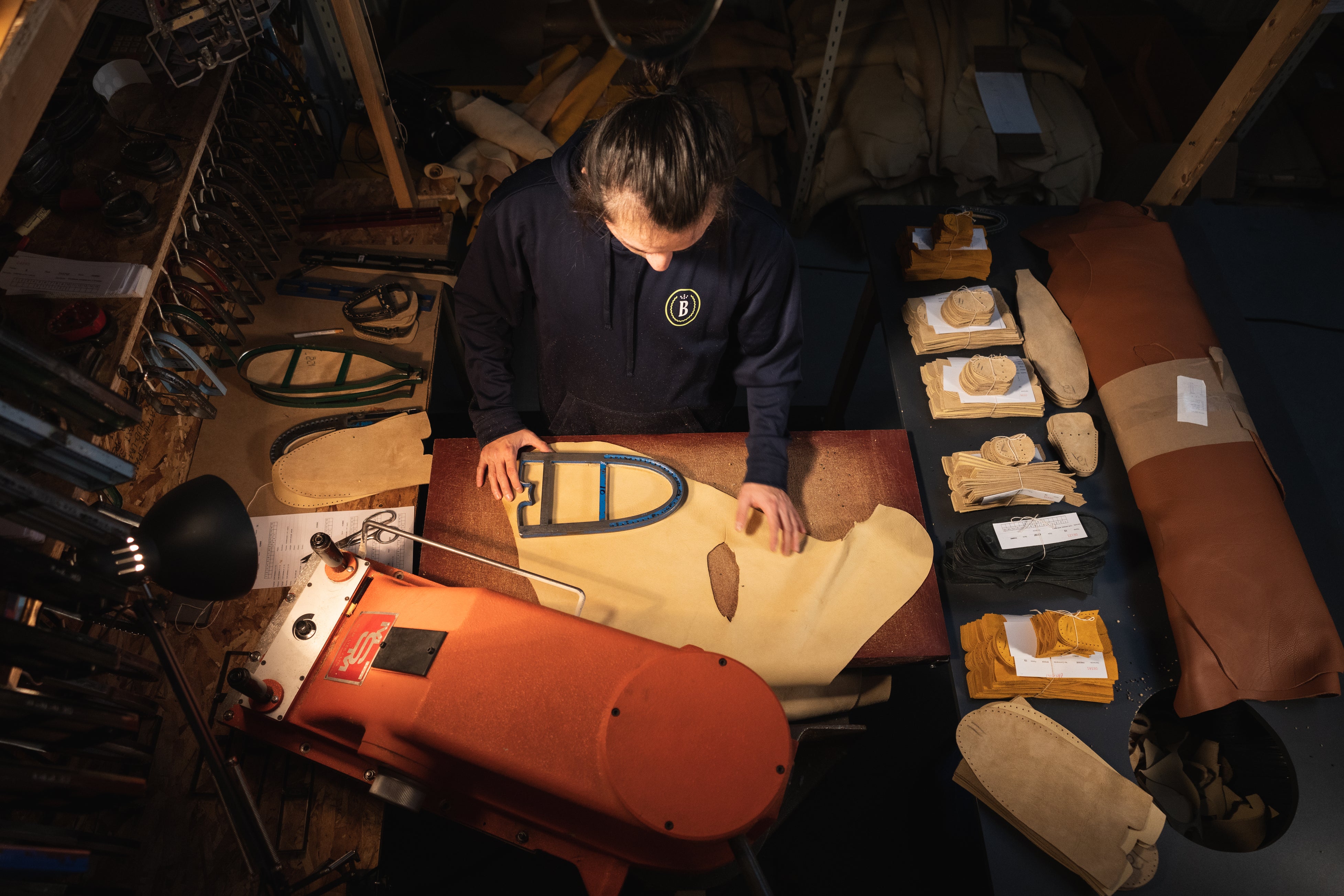 An employee cuts leather.