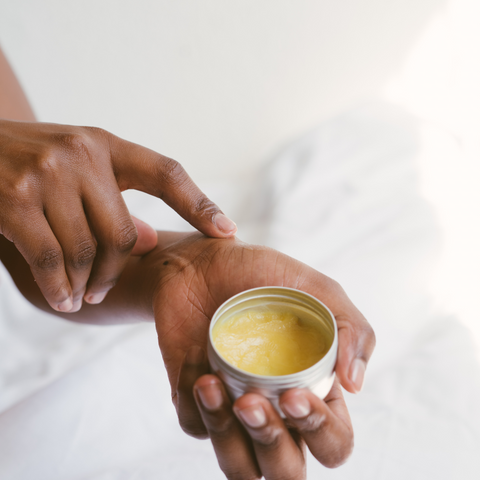 Person applying cream on hand brown skin