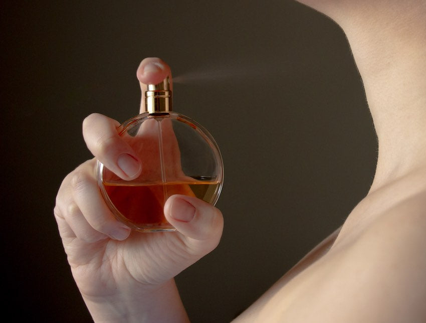 Woman spraying perfume