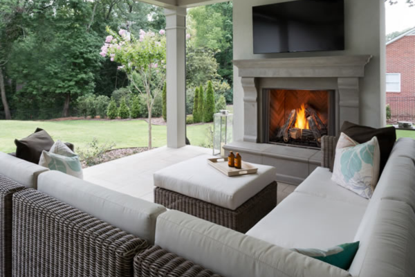 Contemporary outdoor gas fireplace on a covered patio with flat screen TV above