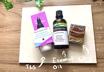 package of translucent liquid sculpey, essential oil, and polymer clay on a white board