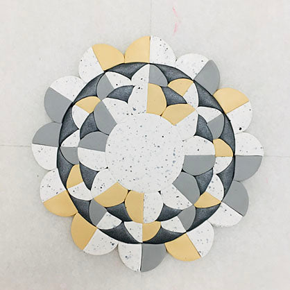 Use the 1.25” cutter to cut out more circles from White Granite, Ecru, and Concrete. Cut these circles into fourths. Arrange the pieces around the outside as shown. 