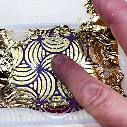photo shows removing excess gold leaf