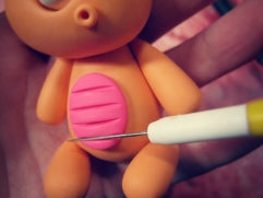 clay knife to cut pink polymer clay belly