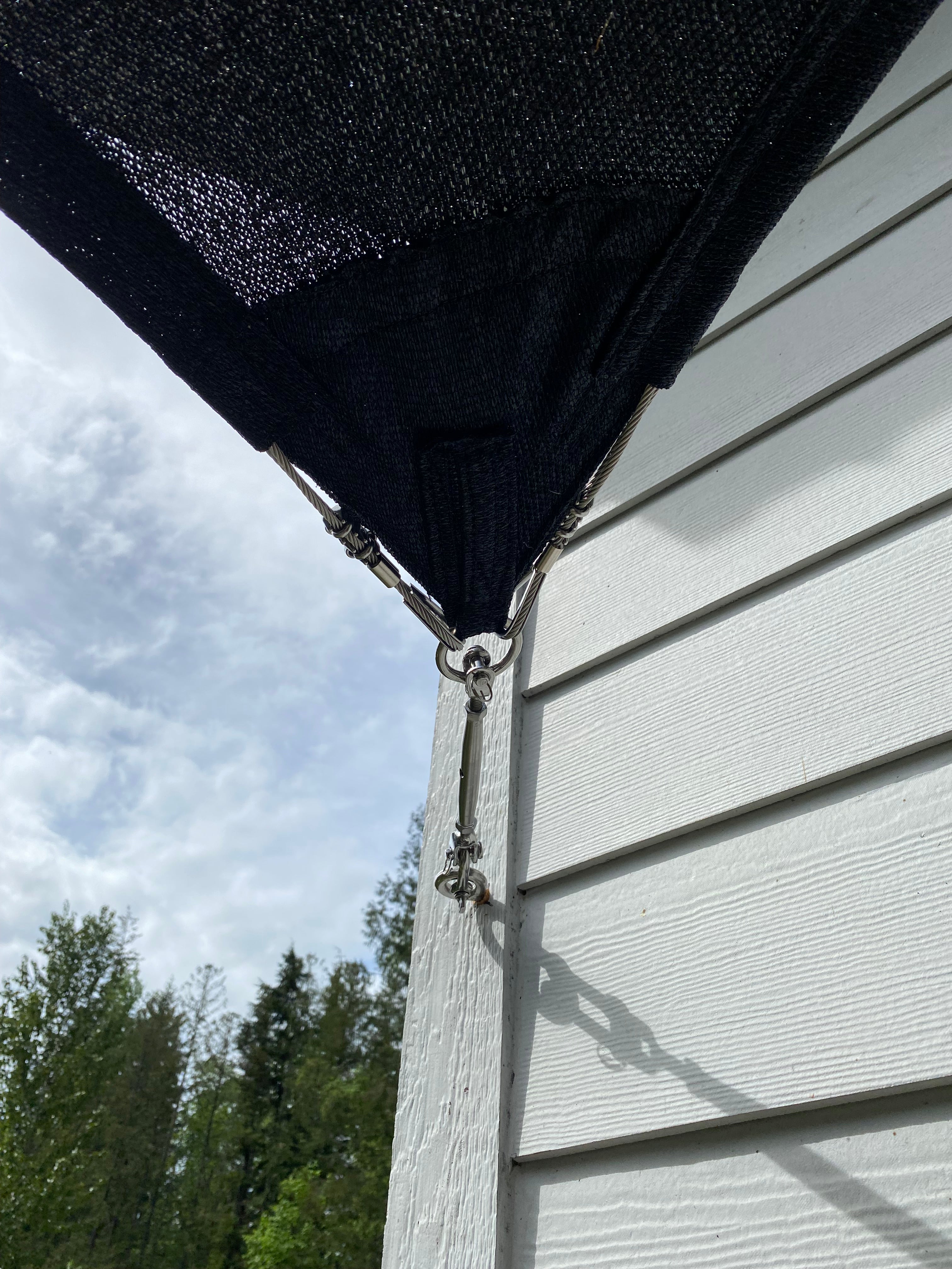 close up of shade sail hardware attached to a building showcasing commercial shade installations