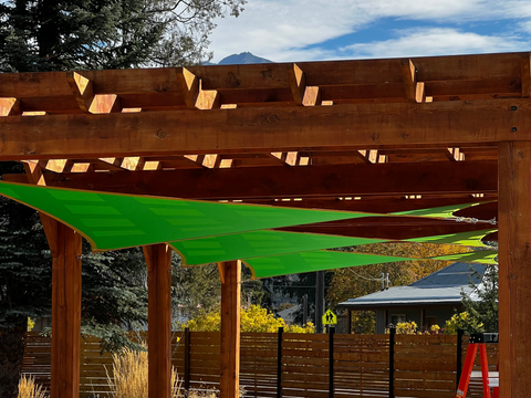 image of green shade sails on a pergola in a backyard.