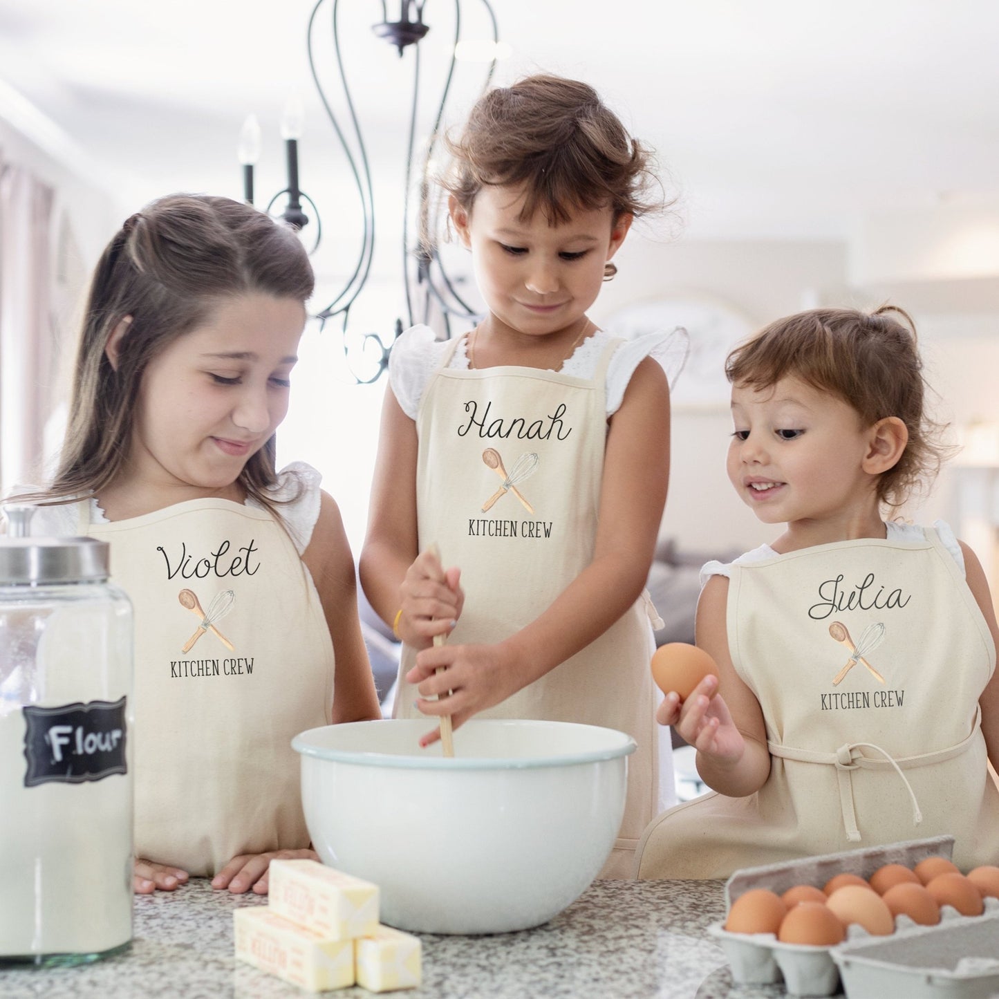 https://cdn.shopify.com/s/files/1/0667/8039/7863/products/kitchen-crew-kids-apron-cousins-apron-gift-idea-sisters-gift-idea-holiday-baking-gift-idea-personalized-kids-kitchen-apron-613087_1445x.jpg?v=1668884077