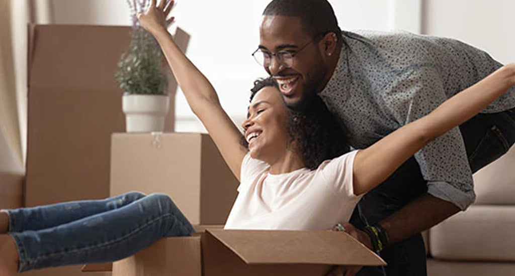 Woman sitting in a box while being pushed around by her husband