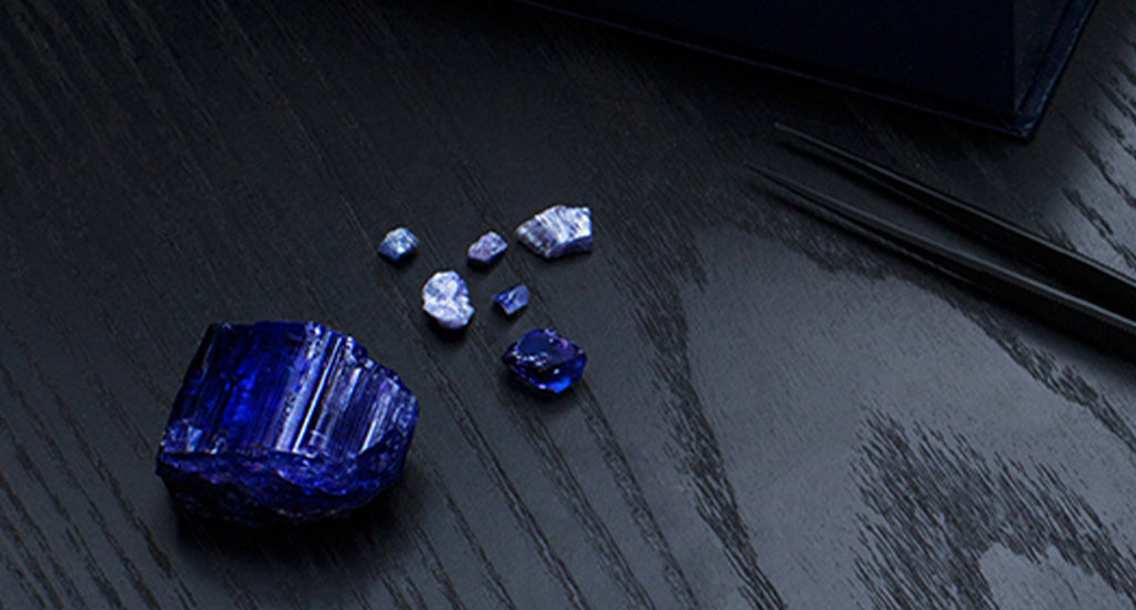 Rough tanzanite on a dark wooden table - Shimansky