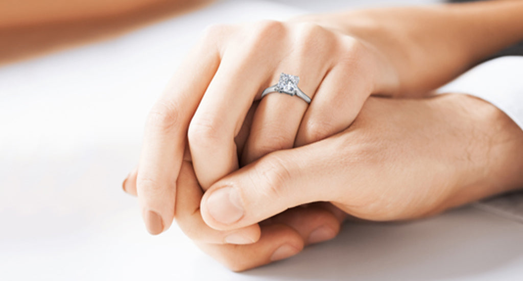 Man and woman holding hands with a Shimansky Ring on the woman's finger