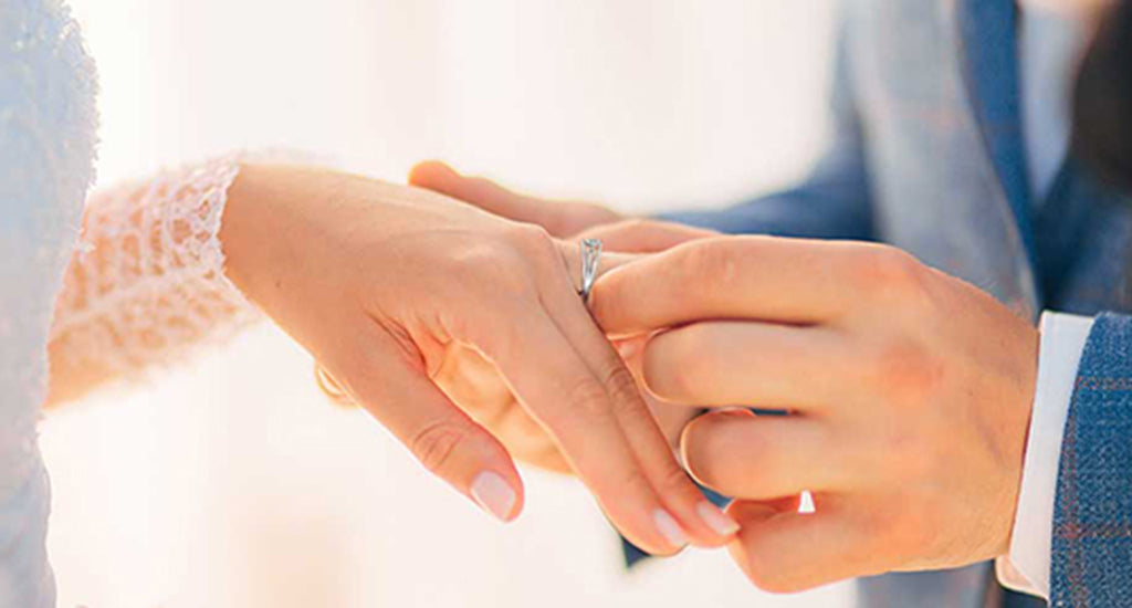 Man putting a Shimansky Evolym Ring on his wife's finger