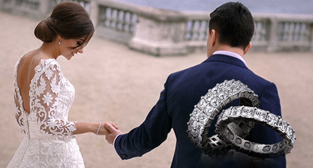 My Girl Eternity rings in the foreground with a couple on their wedding day