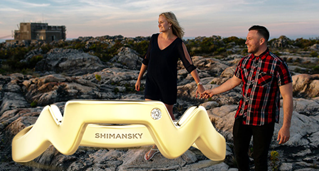 Shimansky Table Mountain Gold Swiss ring with a couple on Table Mountain in the background 