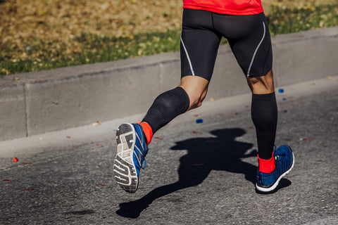 Man running wearing calf compression sleeves