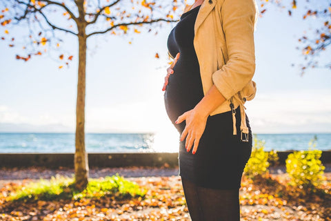 Pregnant Woman standing in front of a tree