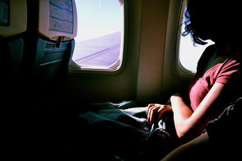 Woman sitting on a plane wearing TXG Flight Socks