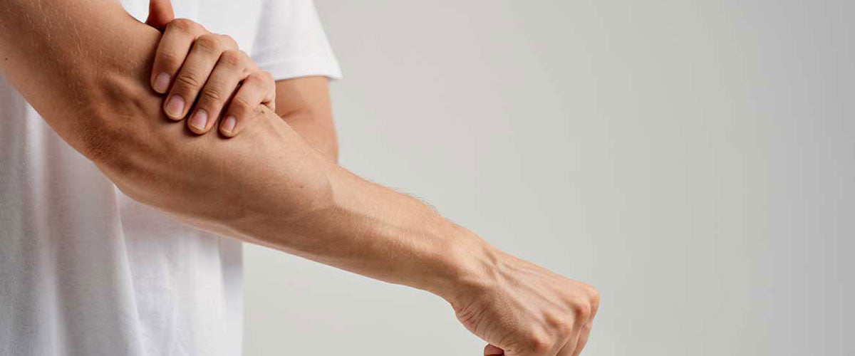 Homme souffrant de douleurs au bras, qui peuvent être traitées avec un appareil TENS