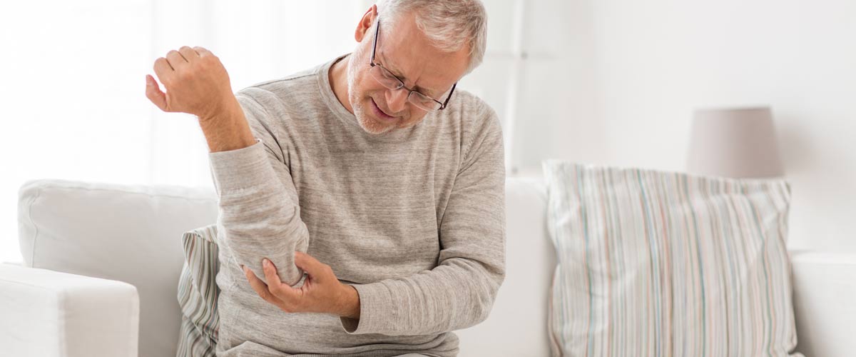 Homme tenant l'intérieur de son coude dans la douleur. Les problèmes à l'intérieur du coude sont appelés coude du golfeur ou coude du golfeur, qui peuvent être traités avec un appareil TENS.