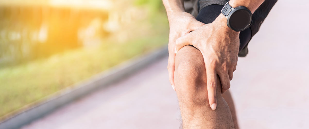 Jogger hält sich das Knie aufgrund von Knieinstabilität, was mit EMS behandelt werden kann