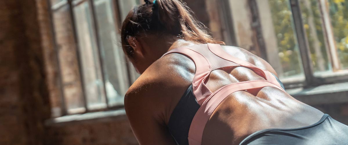 Femme faisant des exercices dans la salle de gym pour renforcer ses muscles du tronc et du bas du dos avec EMS