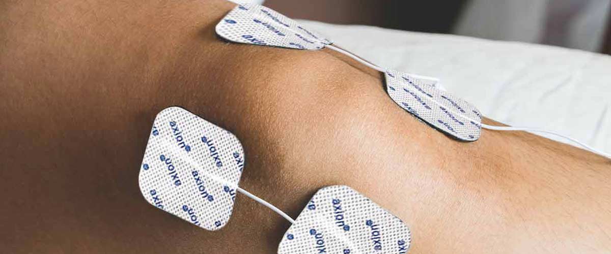 axion Elektroden für ein TENS Gerät auf der Haut im Bereich des Knies