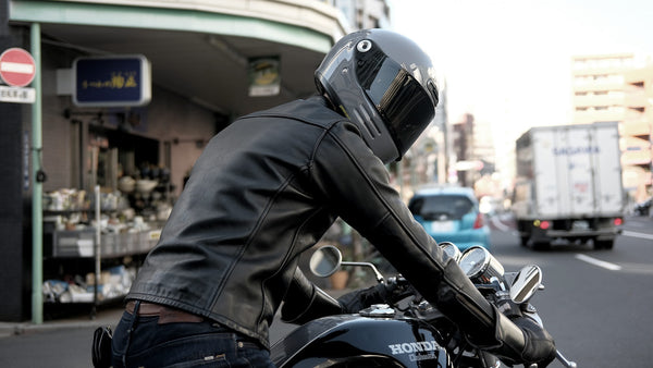 Un hombre que lleva un TSR y a horcajadas en una motocicleta