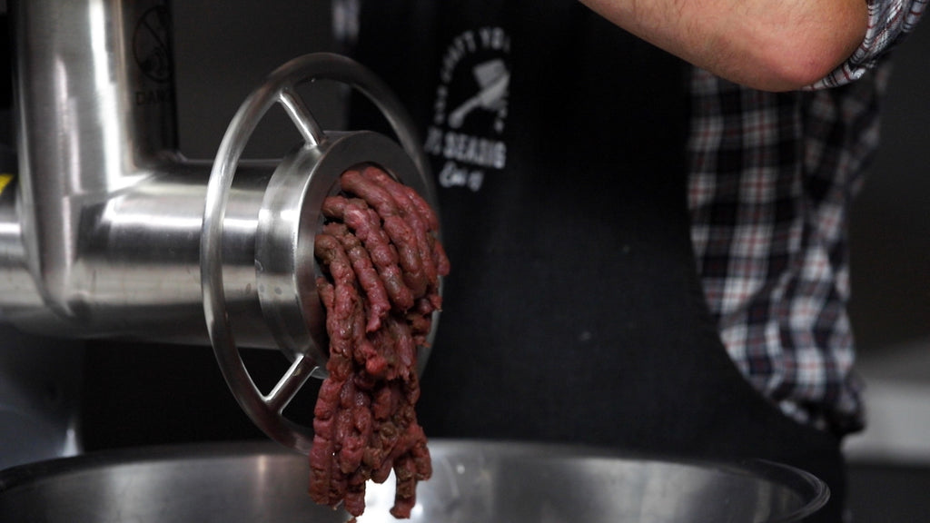 venison sausage deer meat going through the grinder a first time