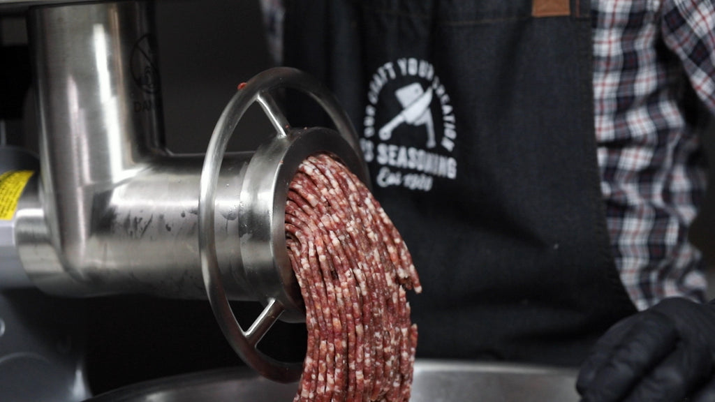Venison sausage meat mix passing through the meat grinder
