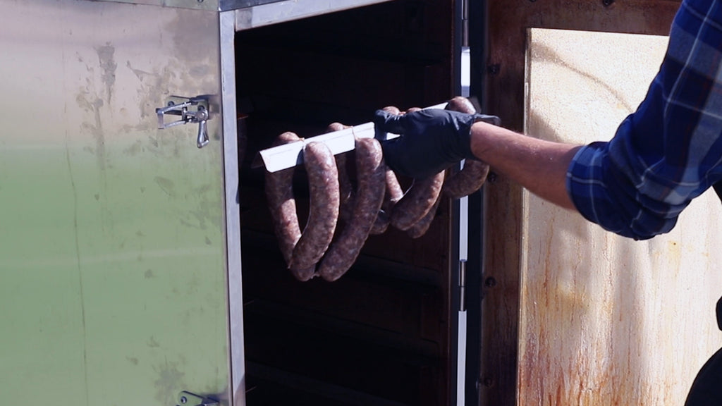 loading venison sausage in smoker