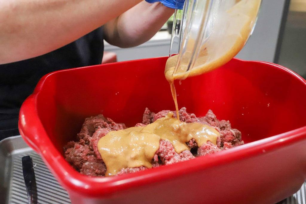 binder flour, water and sausage seasoning being added to the hot dog preparation mix