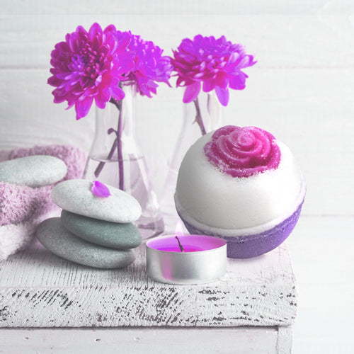 lavender bath bomb next to flowers in vase