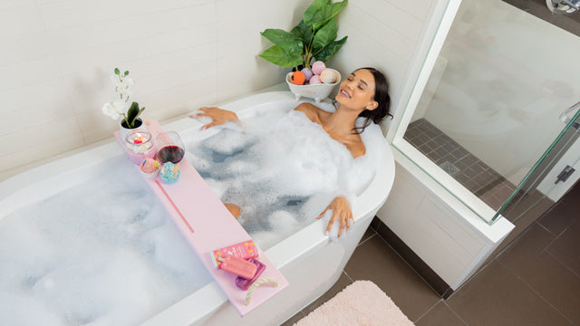 woman closing eyes while enjoying soak in bathtub