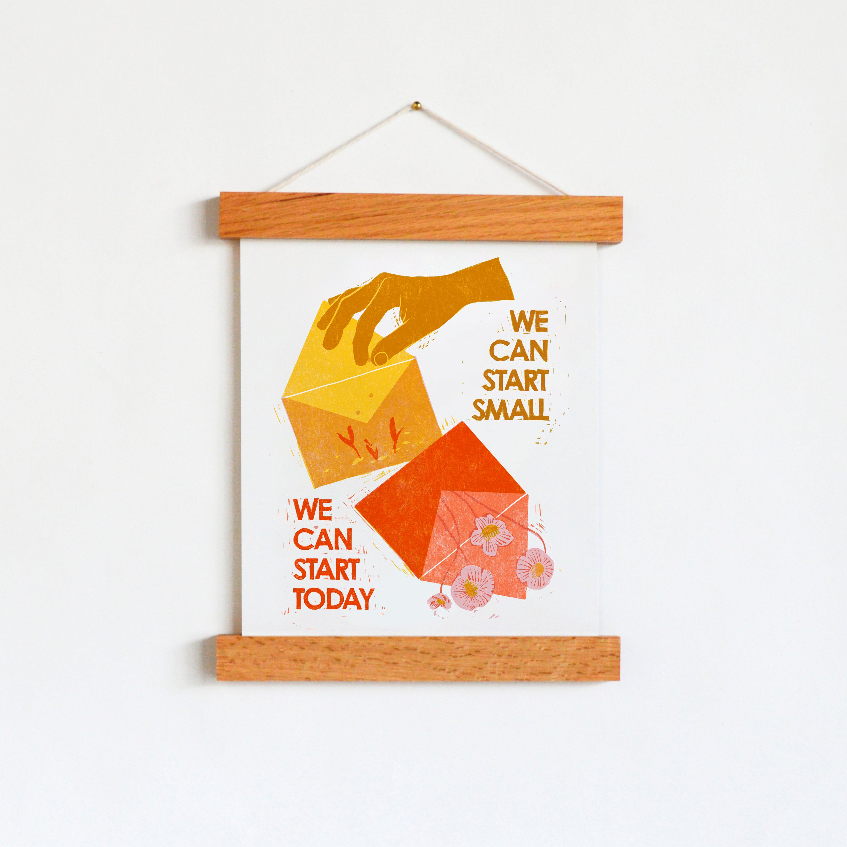 An image of an art print hanging in a frame with an image of a hand planting seeds in an envelope that says "We can start small, we can start today."