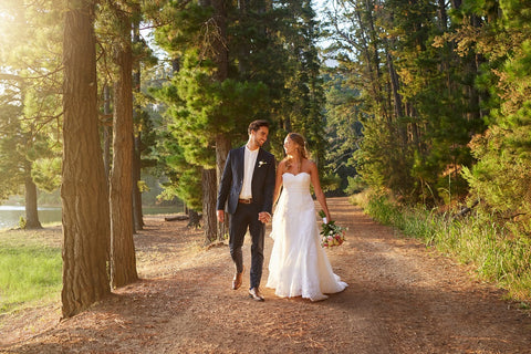 Couple de jeunes mariés en promenade au bord d'un lac