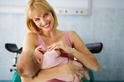 Jeune maman blonde tenant son bébé dans les bras - tableau personnalisé naissance