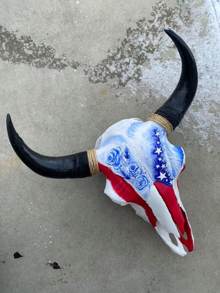 Bison skull painted with vivid American flag-esque red, white, and blue pattern